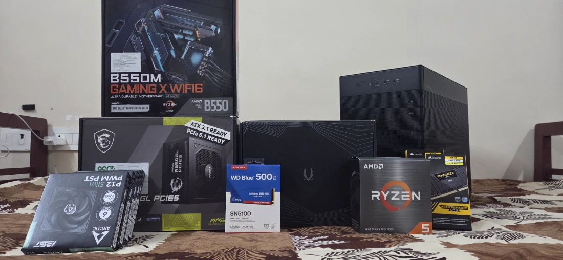 The full parts haul, boxed and laid out before the build — motherboard, PSU, GPU, CPU, RAM, SSD, case and fans